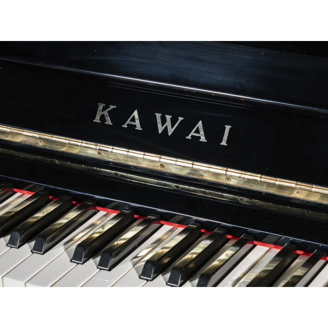 Detalle del teclado y logo de bronce de piano vertical Kawai BL51